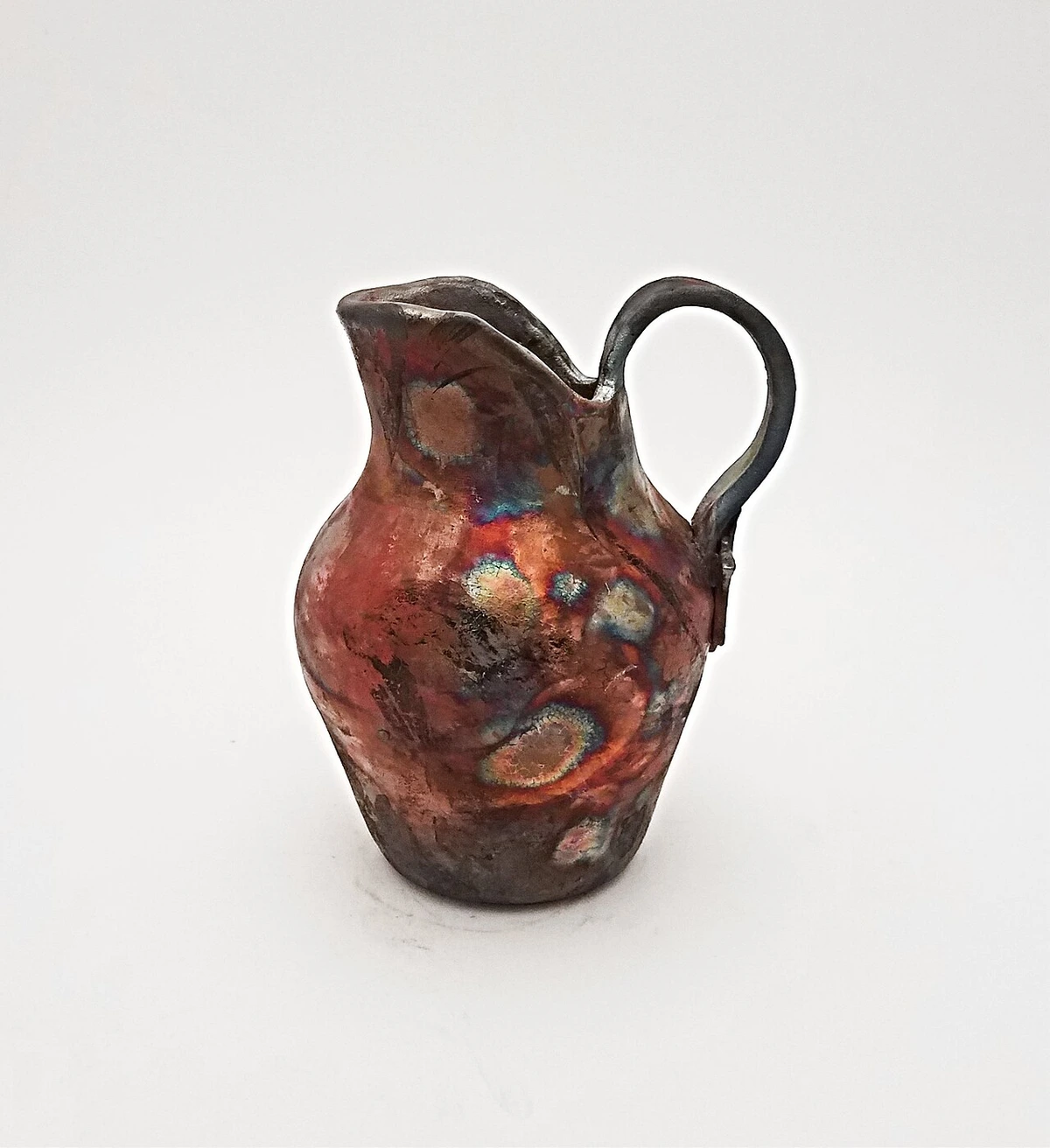 Handgefertigter Raku-Keramikkrug mit bunter Glasur, typische Raku-Oberfläche