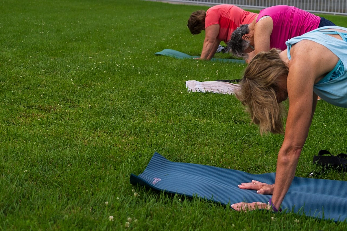 Yoga-Übung im Freien auf einer Wiese im Park, natürliches Licht