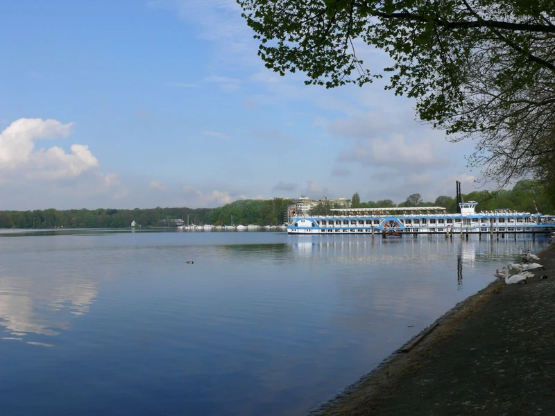 Tegeler See am Alt-Tegel-Hafen im April - Ausflugsschiff am Steg, ruhiges Wasser, Bäume am Ufer.