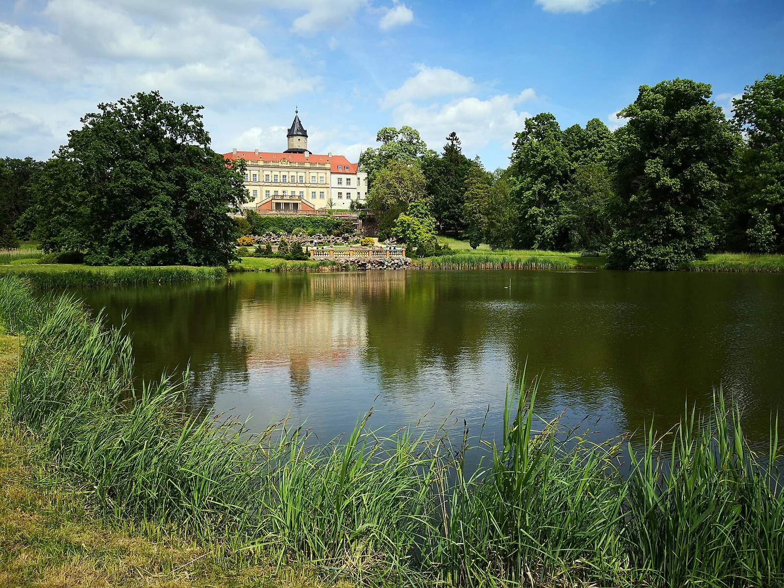 Schloss Wiesenburg mit grünem Park und Teich im Naturpark Hoher Fläming